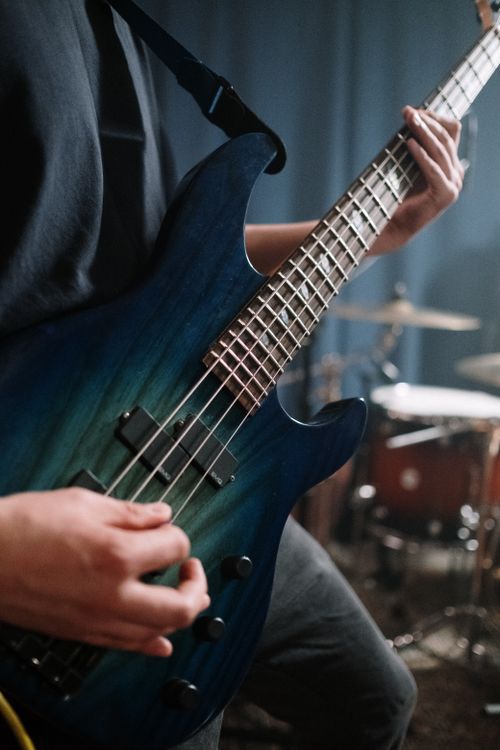 Free Detailed view of a musician playing a blue bass guitar in a sound studio, showcasing musical performance. Stock Photo