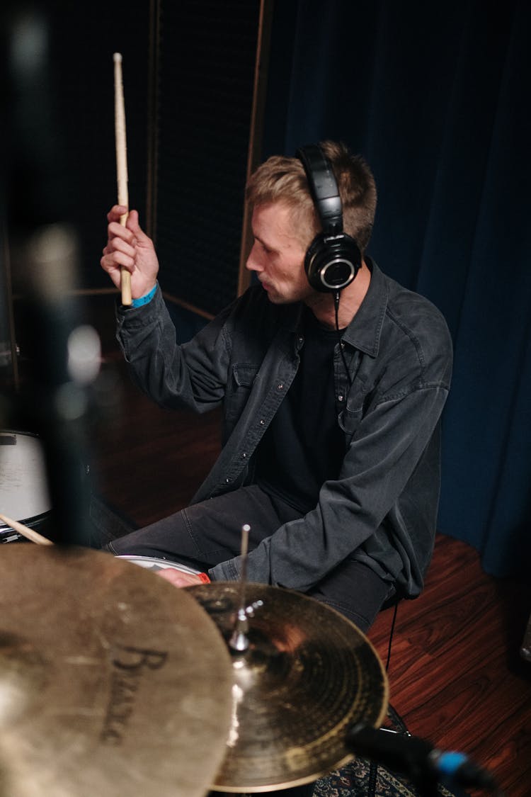 Man Wearing Headphones Playing Drums