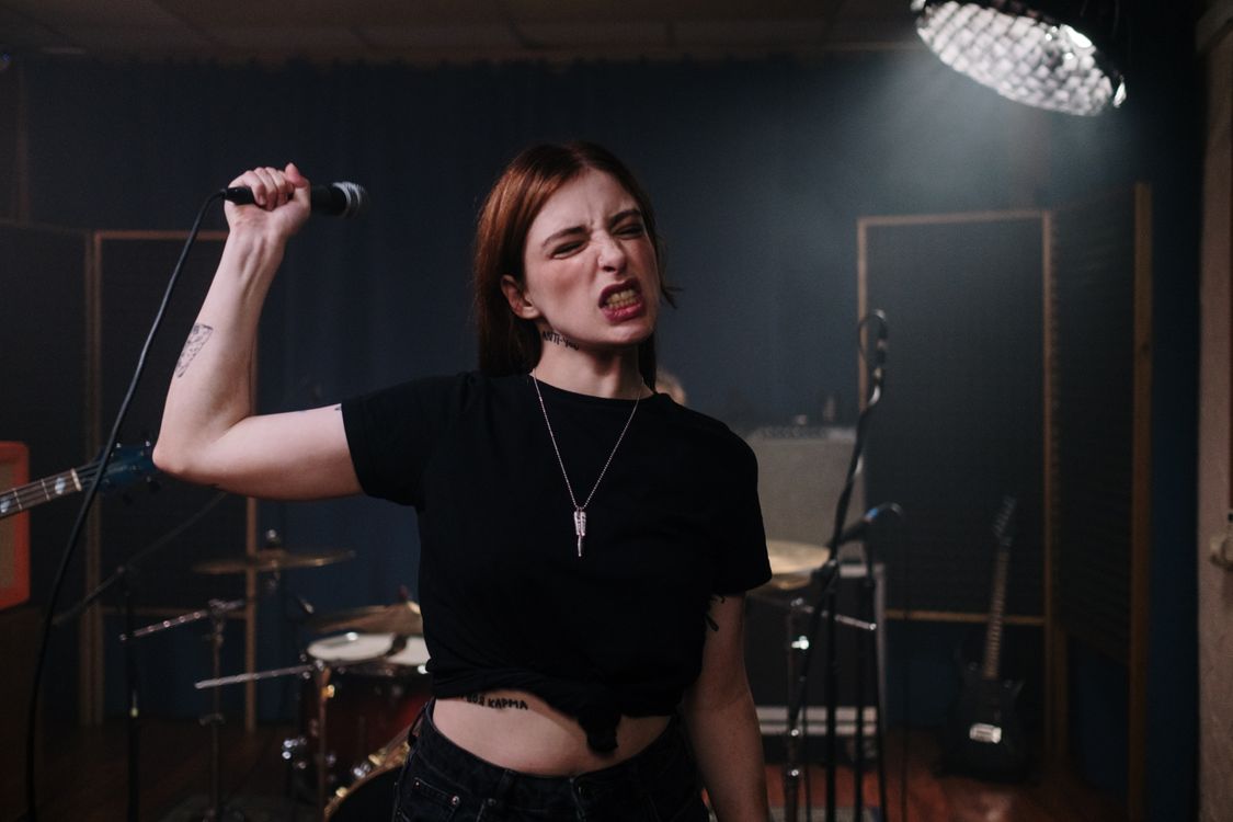 Singer Holding a Microphone at a Rehearsal · Free Stock Photo