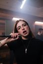 Woman in Black Long Sleeve Shirt Holding Microphone