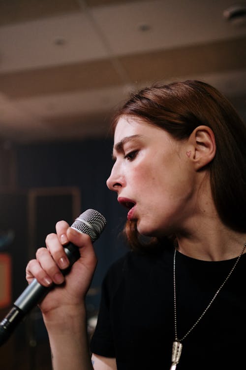 Close-Up Shot of Woman in Black Shirt Singing