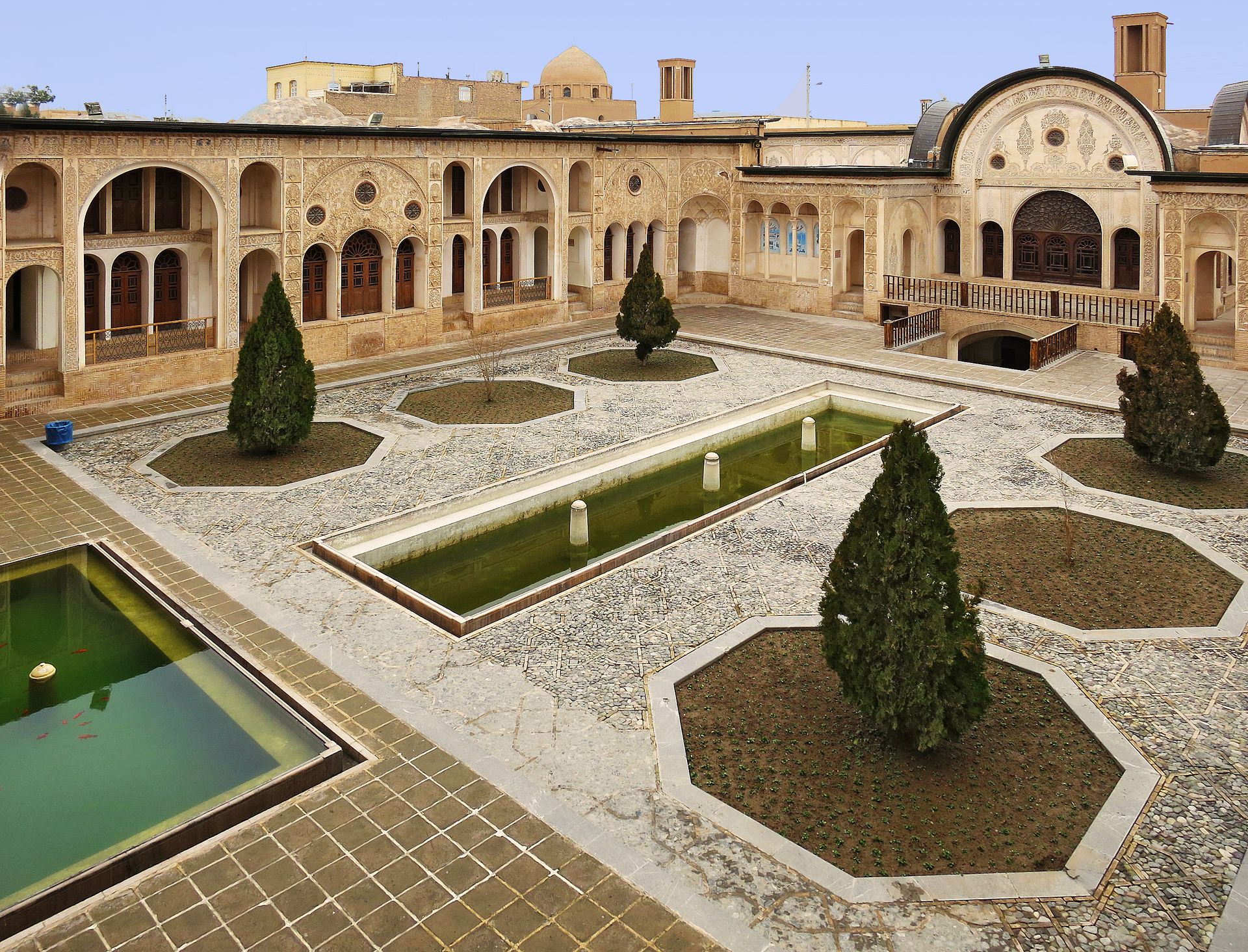 A traditional Persian courtyard featuring stunning architecture, arched windows, and serene fountains, capturing cultural splendor.