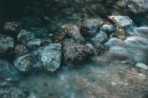 Rough stones in sea water in daylight