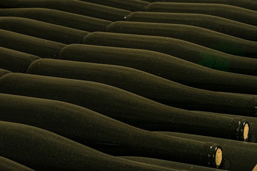 Free From above of glass bottles placed side by side in rows in winery cellar Stock Photo