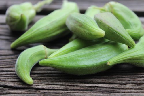 Free Macro shot of green okra pods on rustic wooden surface, highlighting fresh produce. Stock Photo