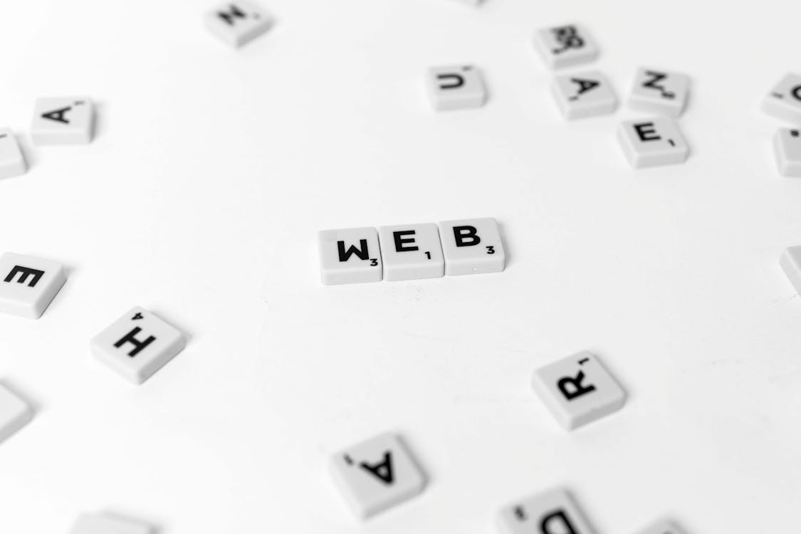 Free White and Black Scrabble Tiles on a White Surface Stock Photo