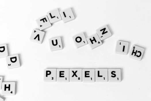 Scrabble tiles scattered on a white background, perfect for word games and creativity themes.