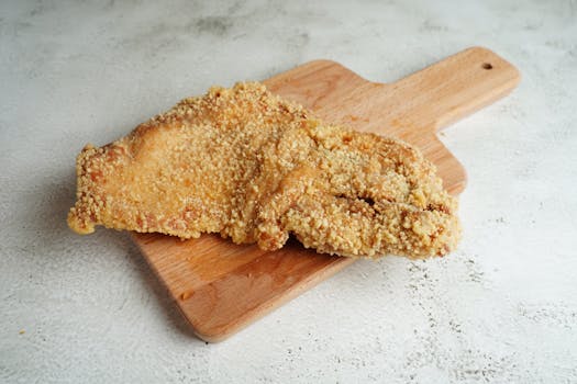 Delicious fried pork chop on a wooden cutting board, perfect for food photography.