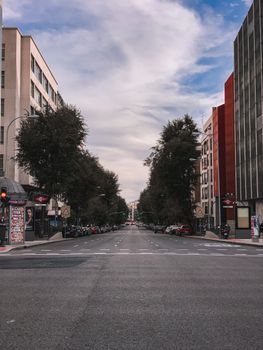 A quiet city street with lined trees and buildings, showcasing urban architecture and symmetry.