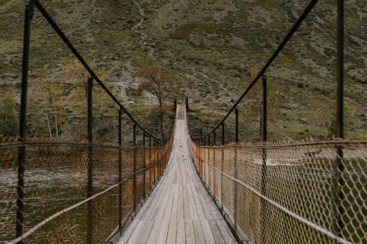 探索这座横跨于郁郁葱葱山谷中宁静河流上的乡村木制人行桥
