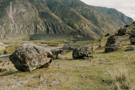 宁静的乡村环境中，有山脉、草原和巨石的风景
