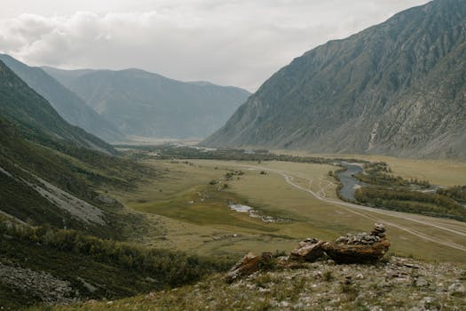 Stunning view of a peaceful valley surrounded by towering mountains.