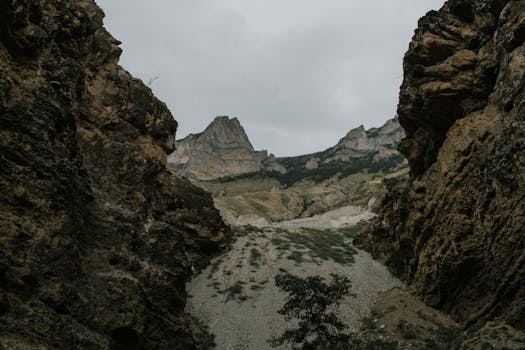 A breathtaking mountain canyon landscape with rugged cliffs and cloudy sky.