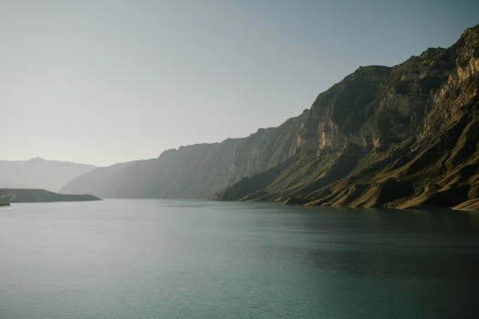 Peaceful lake with majestic mountains under clear sky, ideal for nature lovers.