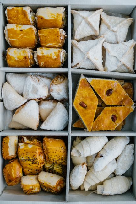 A top view of assorted Middle Eastern pastries in a box, showcasing diverse textures and colors.