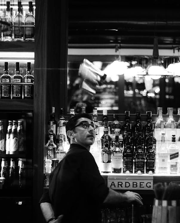 Grayscale Photo of a Man at the Bar · Free Stock Photo