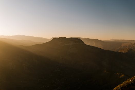 Spectacular view of mountains at sunset with warm golden hues creating a tranquil scene.