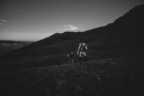 Free Two hikers trekking through mountainous terrain in dramatic black and white, Cesana Torinese. Stock Photo