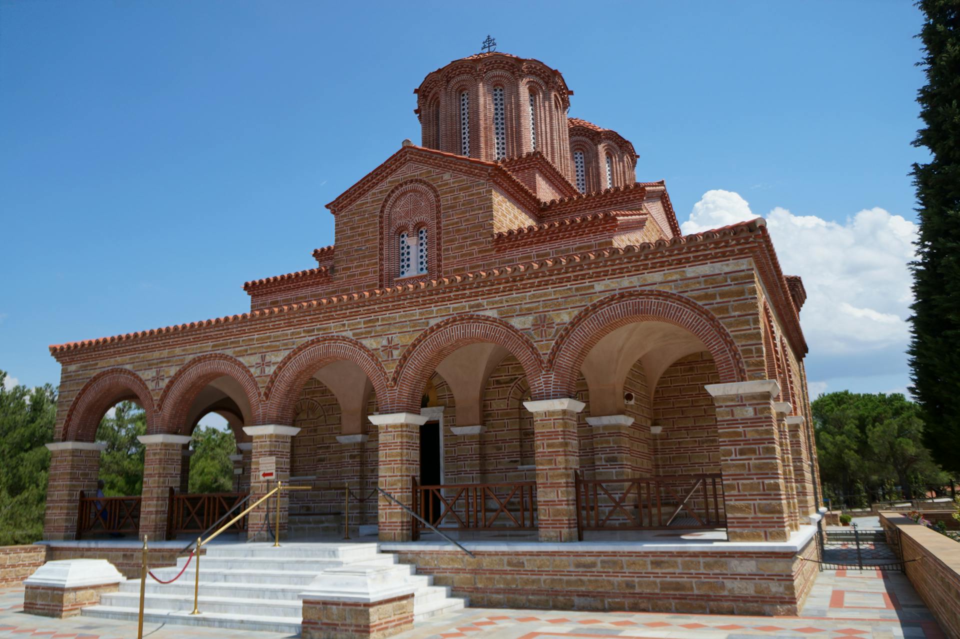 Traditional Greek monastery in Souroti, featuring stunning architecture under a blue sky.