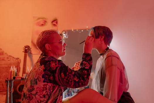Two women engaged in a creative makeup session in a vibrant studio setting.