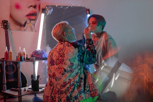 Vibrant studio portrait of makeup artist applying cosmetics to a model's face.