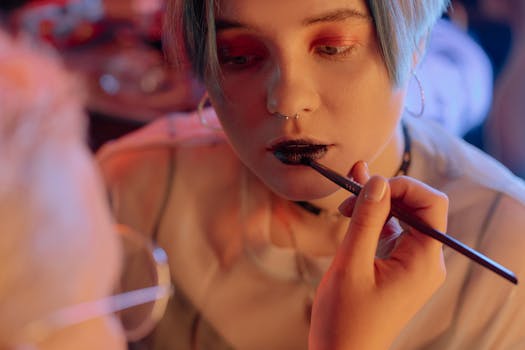 A close-up view of a makeup artist applying black lipstick to a woman. Modern and edgy beauty style.