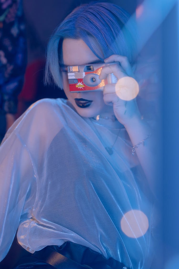 A Woman Using Camera While Posing 