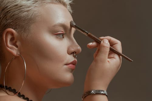Free A Woman Applying Makeup with a Brush Stock Photo