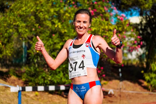 Cheerful female athlete with thumbs up after competition