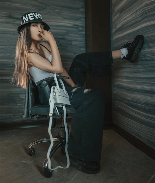 Stylish woman sitting on chair in room