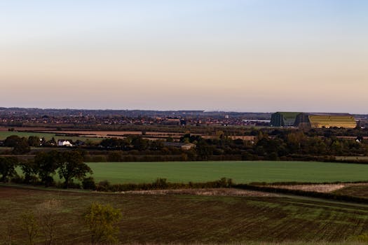 Expansive farmland and countryside under a serene evening sky.