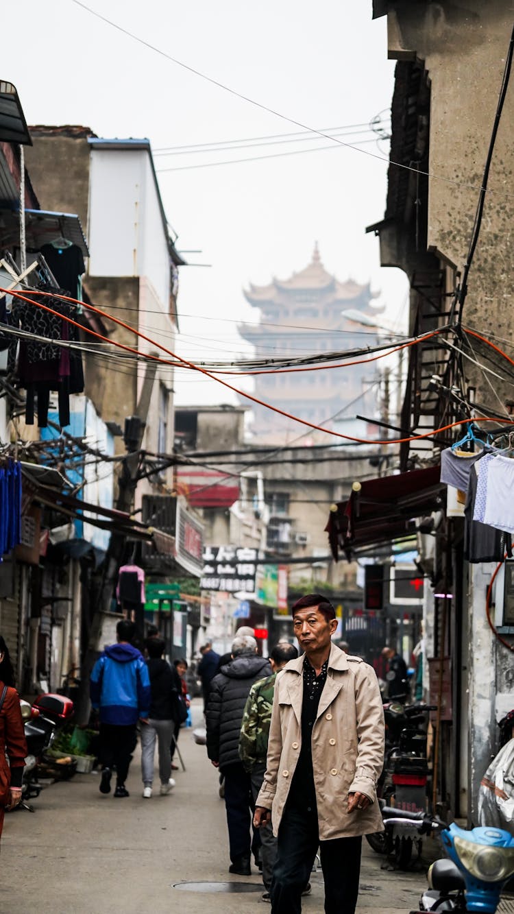 People Walking Through Narrow Street