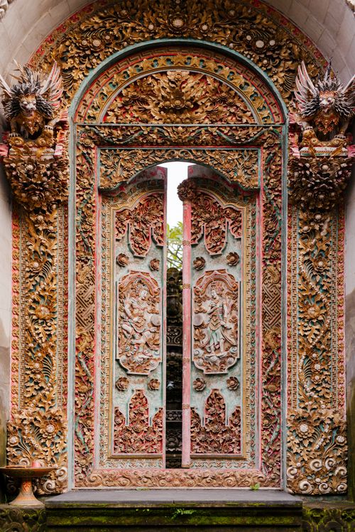 Free A vertically shot, intricately carved Balinese temple doorway showcasing ornate details and cultural art. Stock Photo