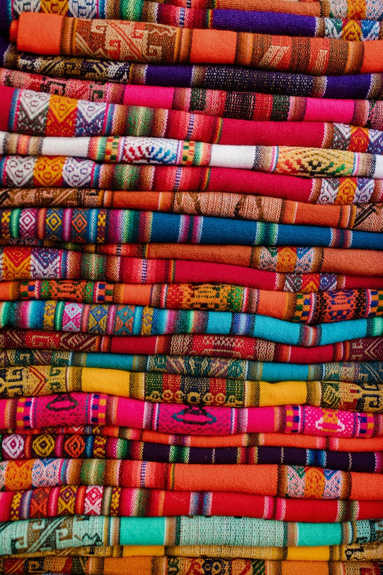 A Pile Of Colorful Folded Textiles