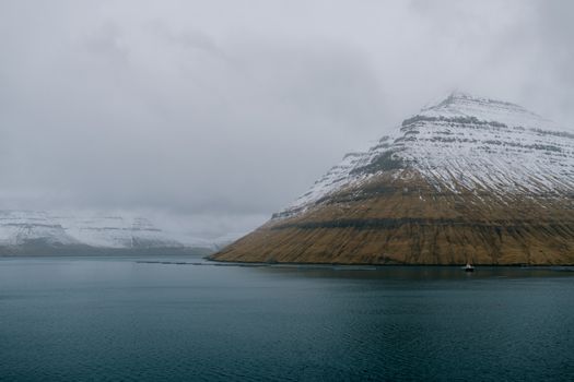冰岛一个宁静的湖泊中，倒映着白雪皑皑的迷人山景，捕捉到了冬天的精髓