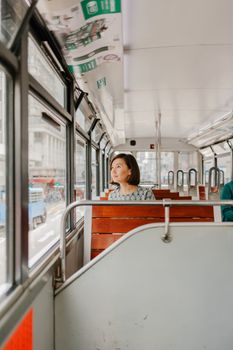 白天，一名妇女望着城市电车的窗外，陷入片刻沉思
