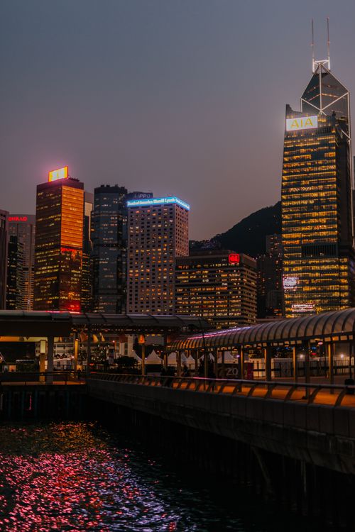 Free Captivating view of Hong Kong's illuminated skyscrapers reflecting in water at night. Stock Photo