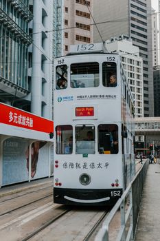 双层电车穿梭于香港市中心摩天大楼之间，充满了活力的城市生活
