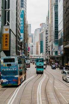 白天，沿着繁忙的街道，充满活力的城市场景与电车和摩天大楼交相辉映