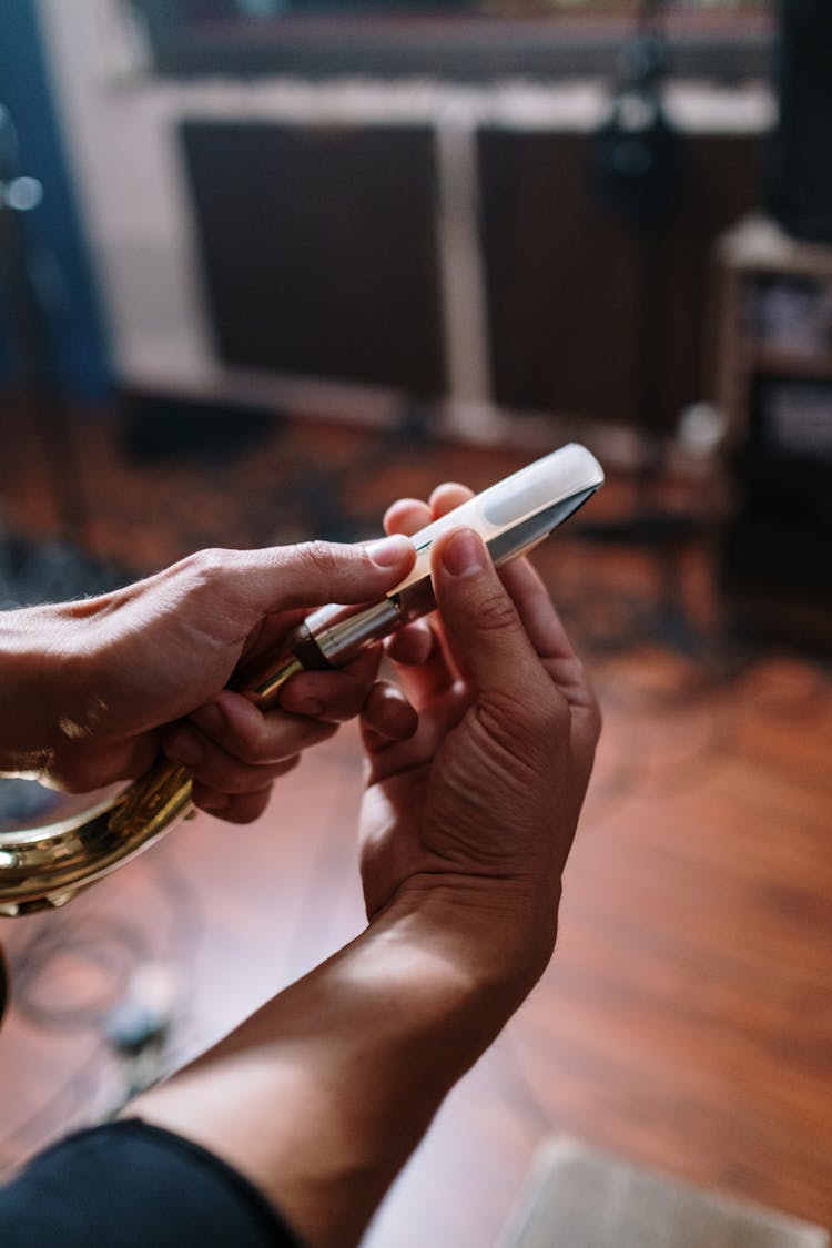 A Person's Hand Holding Saxophone Mouthpiece