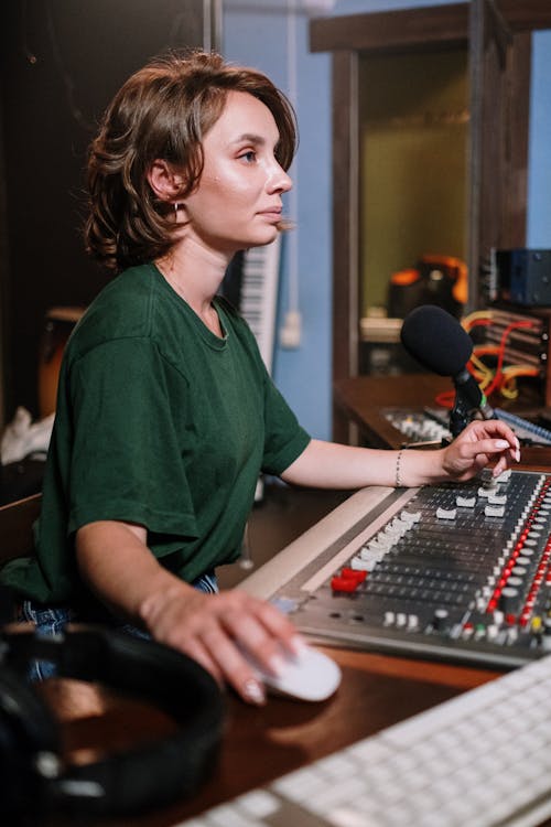 A Woman in Green Crew Neck T-shirt Infront of Audio Mixer