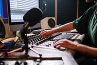 在现代录音室中，专业音频工程师调整混音器