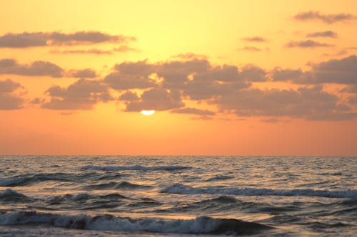 Ocean Waves Crashing on Shore During Sunset