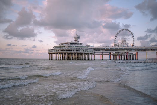 A picturesque seaside pier with a ferris wheel at twilight, offering a serene coastal experience.