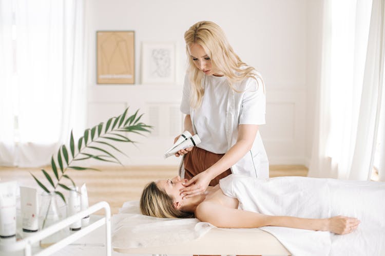 A Dermatologist Checking The Client's Face 