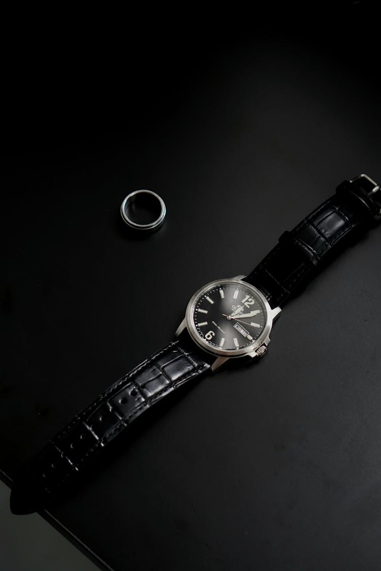 Luxury Male Wristwatch And Ring On Black Background