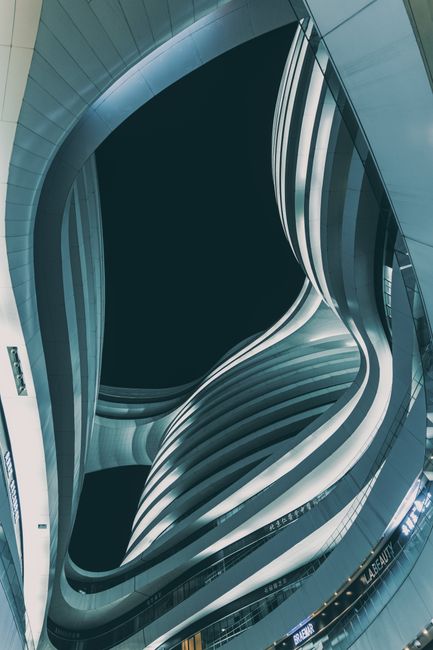 Low angle view of modern Milky Way Soho in Beijing at dusk. Futuristic curves and lines in dramatic urban setting.