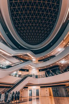 Spacious modern mall with unique architectural ceiling and escalators in Beijing, China.