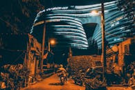 Delivery Rider on the Street Between Houses Near Galaxy Soho Building