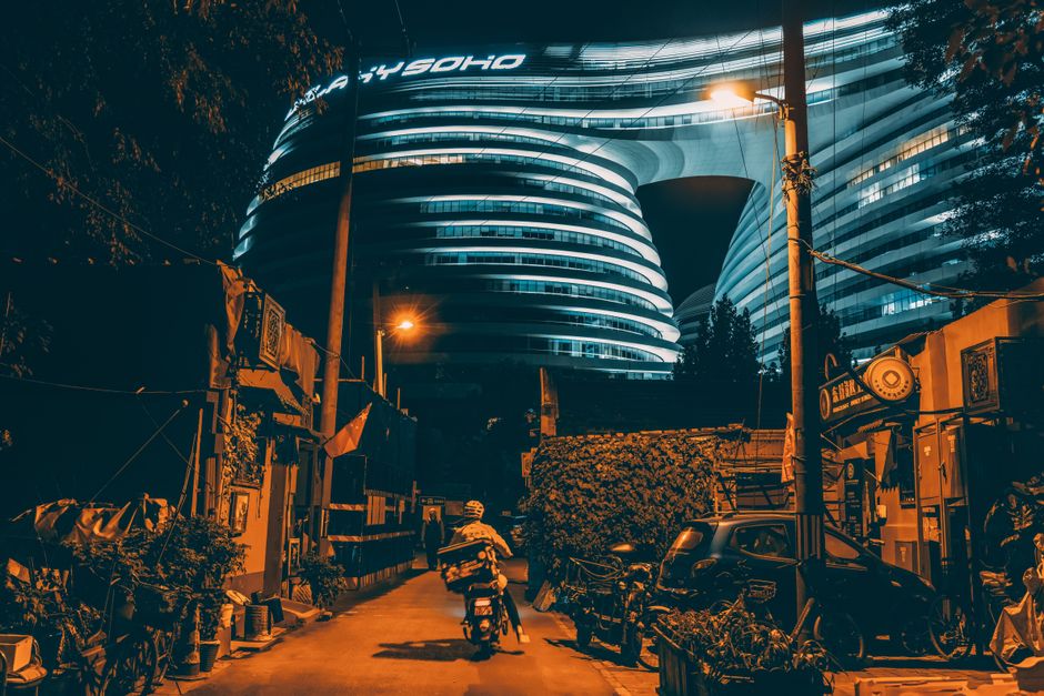 Dynamic nighttime view of Galaxy SOHO in Beijing, highlighting modern architecture and urban life.